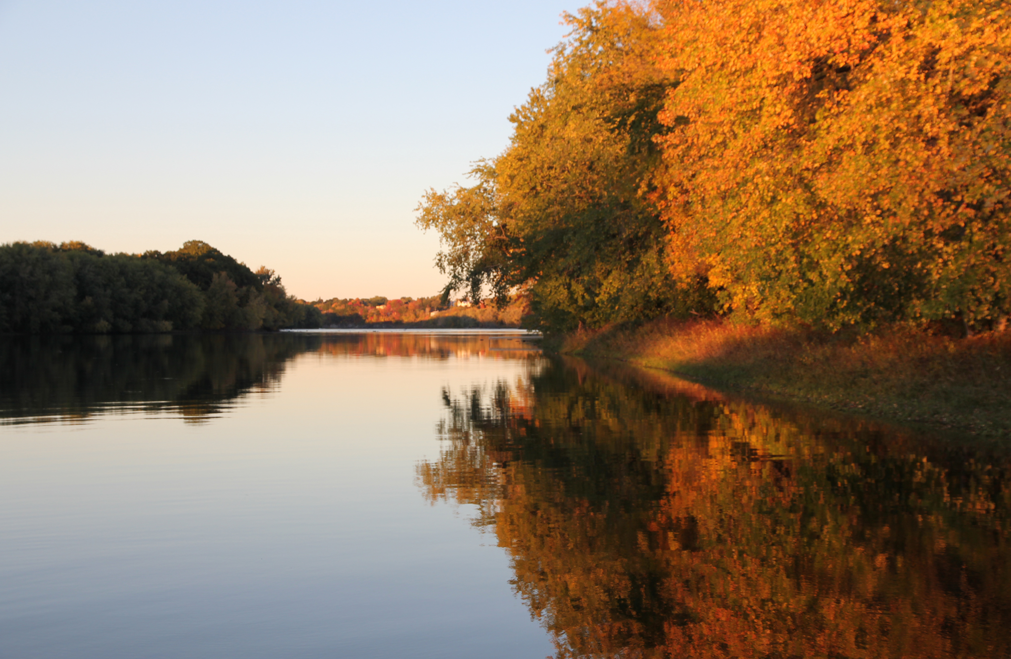 Fall colors reflect off a river.