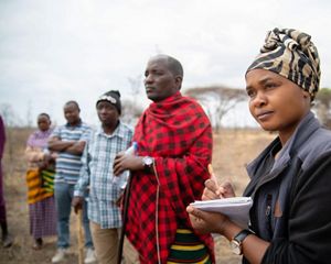 Warda Kanagwa stands with community members in Randilen Wildlife Management Area in Tanzania.