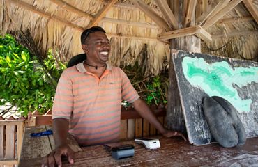 Ron Barbe stands in front of a desk in an outside shelter.