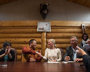 a caribou on yellow-green grasses near a wetland