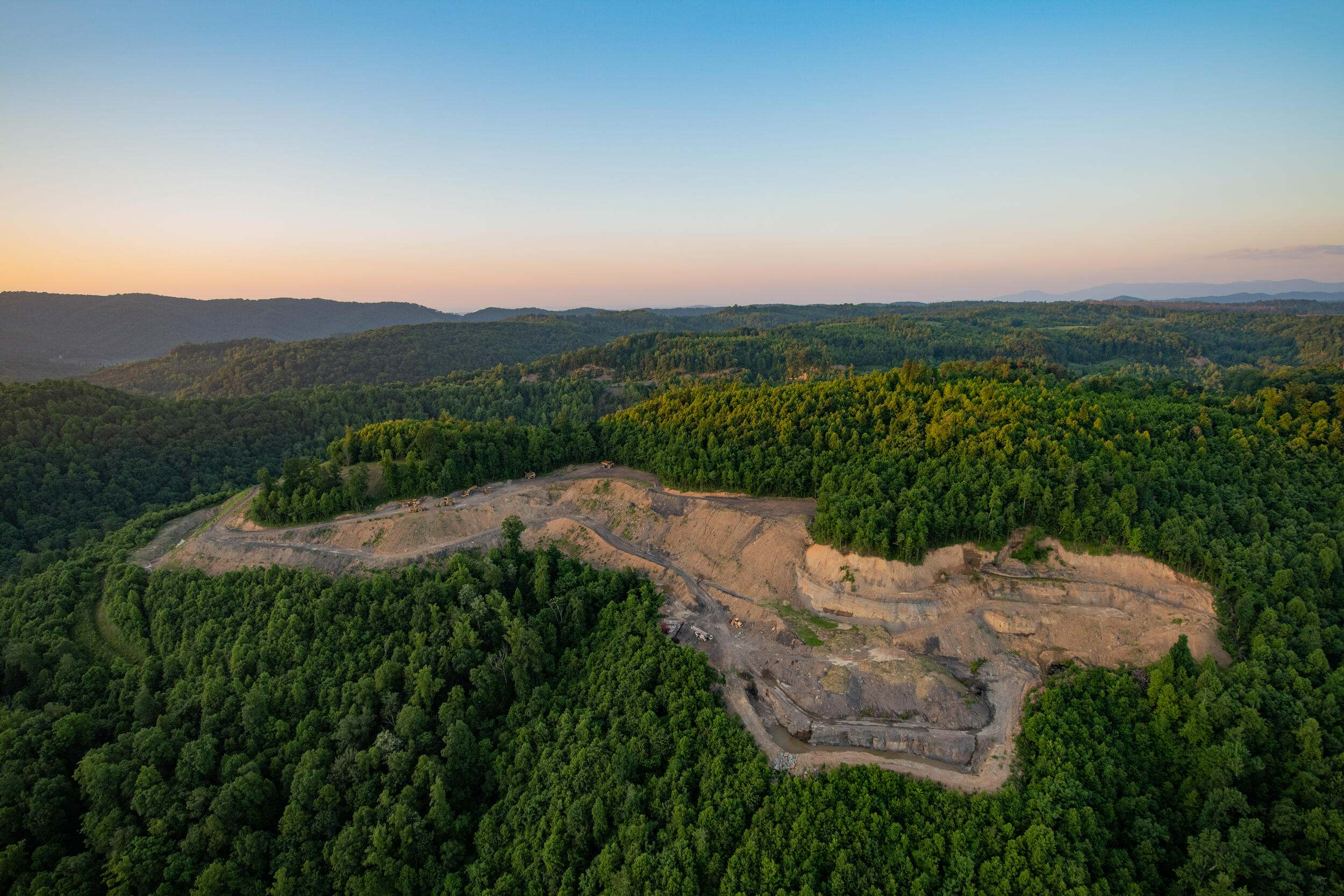 aerial view of surface coal mine in a forest.