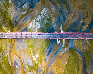 Aerial view looking straight down on a bridge that crosses a wide river.