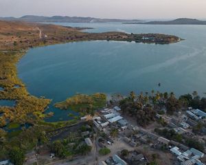 an aerial view of a lake with a village to the side.