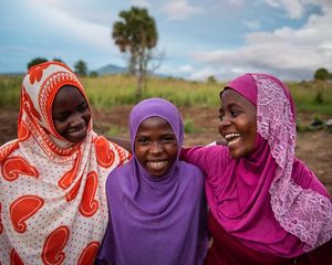 three girls standing together and smiling.